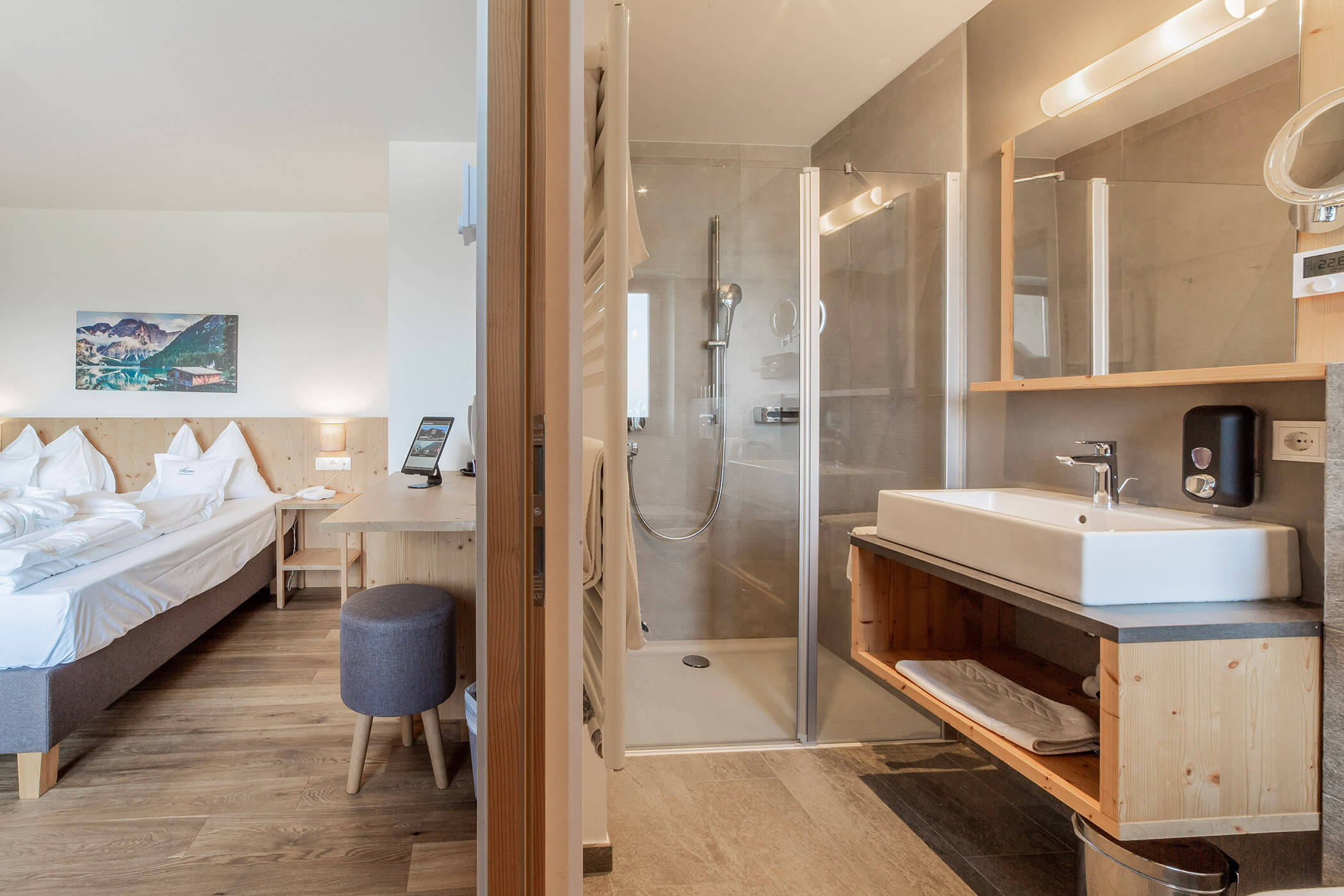 Camera d'albergo con letto matrimoniale, scrivania e bagno moderno annesso con doccia e lavandino. - Hotel Oberwiesen