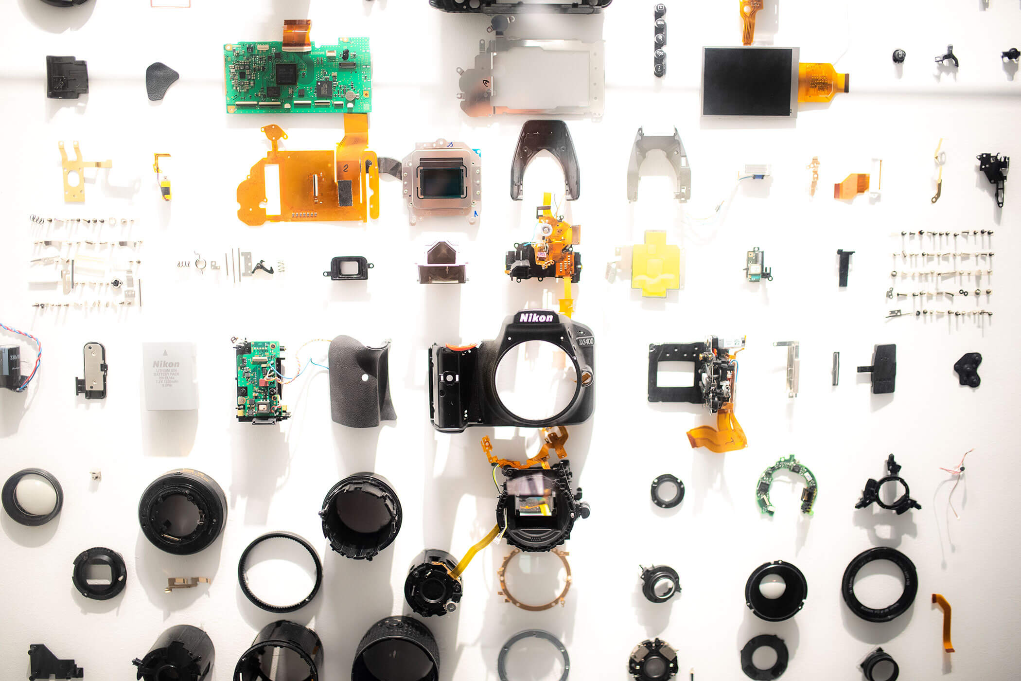 I componenti della fotocamera e quelli elettronici sono disposti in modo ordinato su uno sfondo bianco, secondo uno schema a griglia. - Hotel Oberwiesen