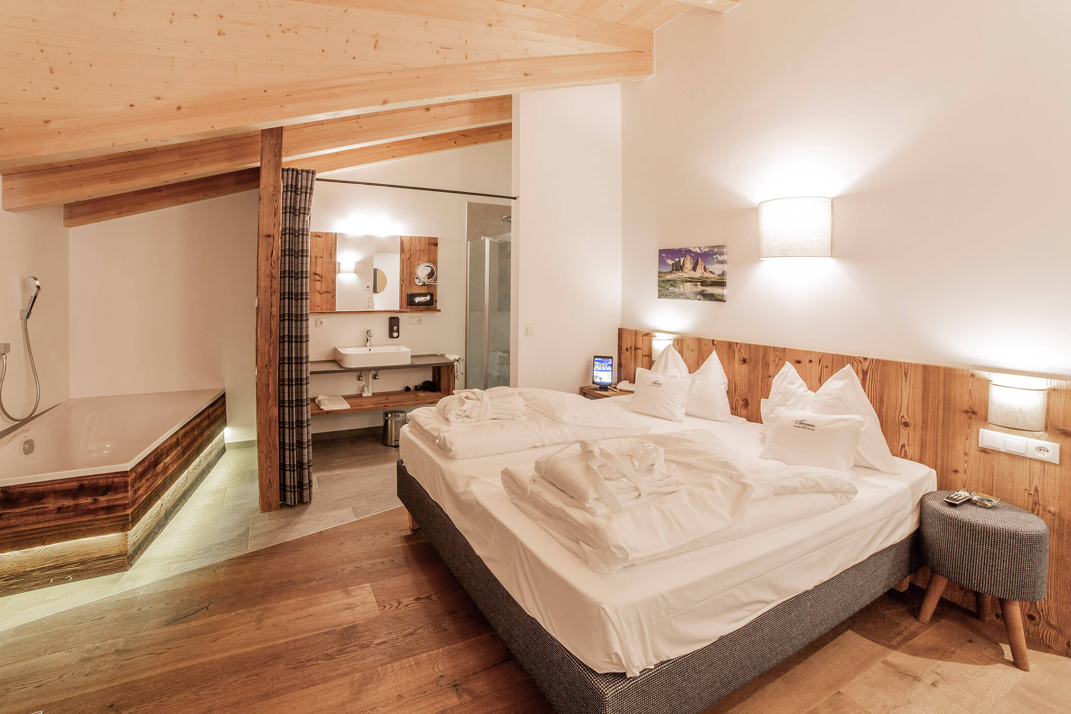 Accogliente camera d'albergo con letto matrimoniale, arredi in legno, bagno privato e vasca da bagno nell'angolo. - Hotel Oberwiesen